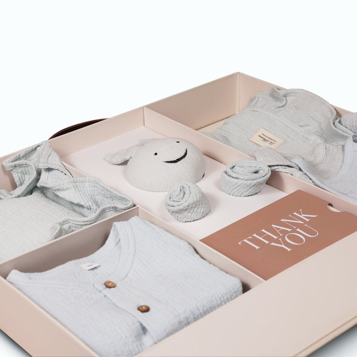 La Plume 7-Piece Muslin Newborn Gift Set | Swaddle, Romper, Bib, Washcloths, Pillow &amp; Soft Toy