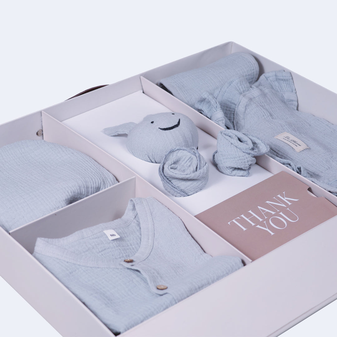 La Plume 7-Piece Muslin Newborn Gift Set | Swaddle, Romper, Bib, Washcloths, Pillow &amp; Soft Toy